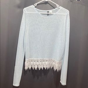 Light blue sweater with design on bottom